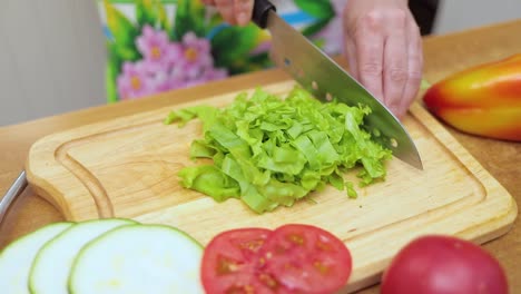 Female-hands-of-housewife-with-a-knife-cut-fresh-lettuce-on-a-chopping-Board-kitchen-table
